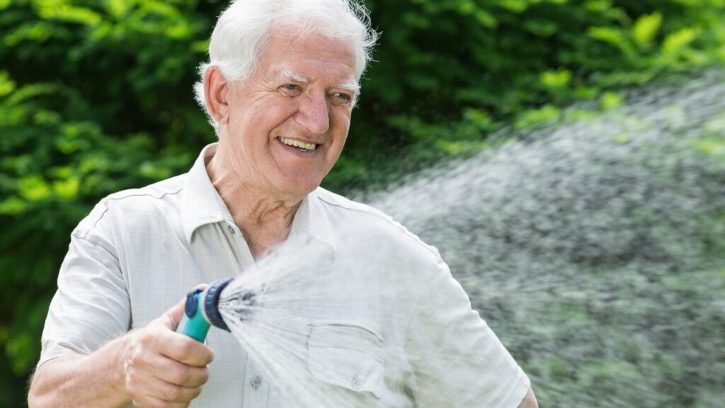 Man using a retractable garden water hose